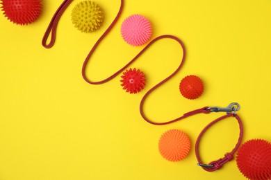 Flat lay composition with dog leash and toys on yellow background, space for text