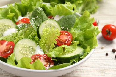 Photo of Delicious salad in bowl on white wooden table, closeup