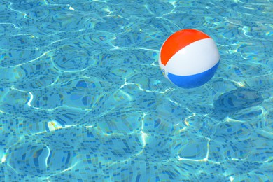 Photo of Inflatable beach ball floating in swimming pool, space for text