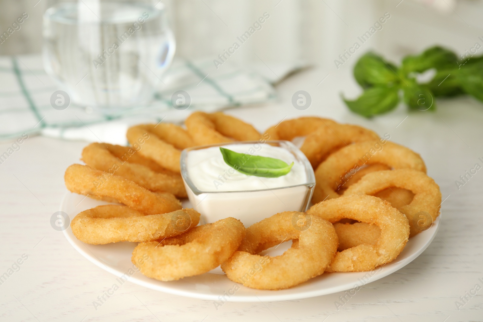 Delicious onion rings with sauce on white wooden table, closeup Photo of Delicious onion rings with sauce on white wooden table, closeup