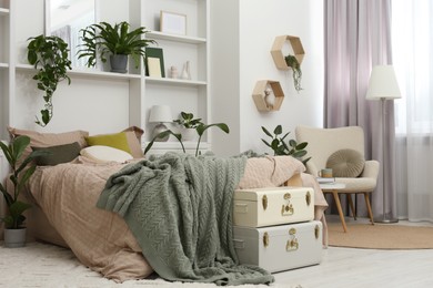 Photo of Stylish bedroom with comfortable bed and different houseplants. Interior design