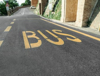 Photo of Bus stop pad on asphalt road on sunny day