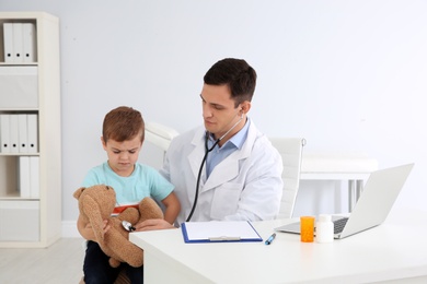 Photo of Children's doctor working with little patient in hospital