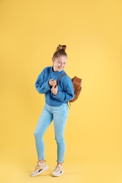 Photo of Portrait of pretty teenage girl with backpack on color background