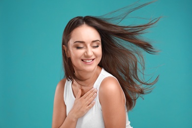 Photo of Emotional young woman in casual outfit on turquoise background