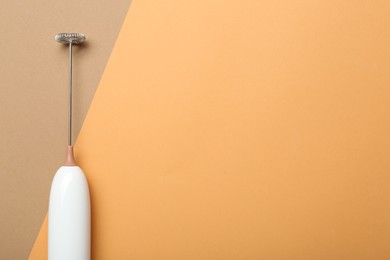 Photo of White milk frother wand on color background, top view. Space for text