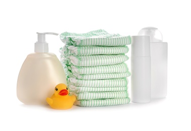 Photo of Stack of disposable diapers and baby accessories on white background