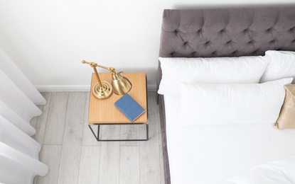 Photo of Stylish room interior with comfortable bed and nightstand, above view