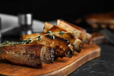 Photo of Delicious roasted ribs served on black table