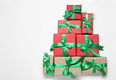 Photo of Christmas tree shape of gift boxes on white background, flat lay. Space for text
