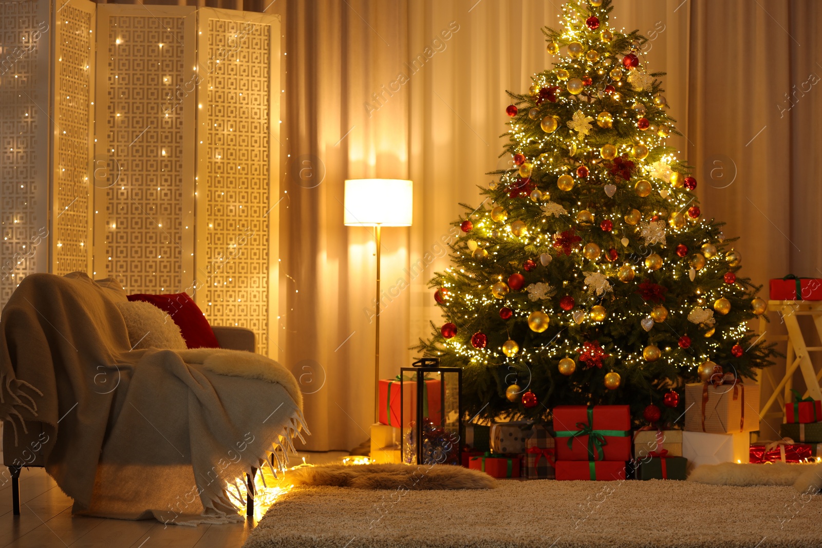 Photo of Beautifully wrapped gifts under Christmas tree in living room. Festive interior design