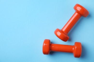 Bright dumbbells and space for text on color background, flat lay. Home fitness