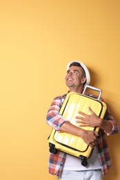 Photo of Young man with suitcase on color background
