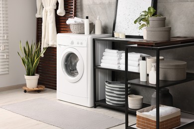Photo of Stylish laundry room with modern washing machine. Interior design