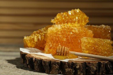 Photo of Natural honeycombs and wooden dipper on rustic table, closeup. Space for text