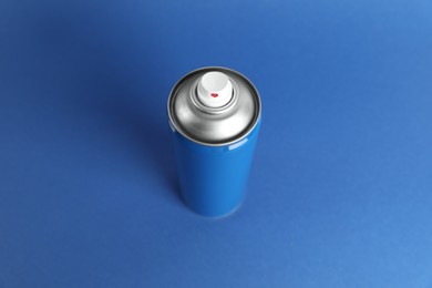 Photo of Can of spray paint on blue background, above view