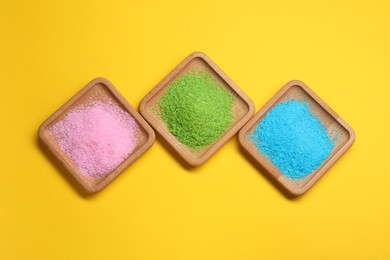 Photo of Different sea salt on yellow background, flat lay
