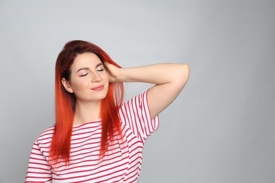 Photo of Young woman with bright dyed hair on grey background