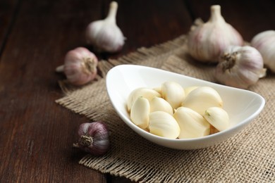 Photo of Fresh garlic cloves and bulbs on wooden table. Space for text
