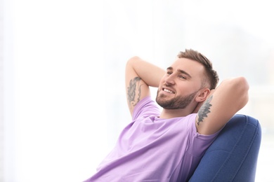 Photo of Portrait of smiling young man in armchair