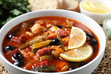 Photo of Meat solyanka soup with sausages, olives and vegetables on table, closeup
