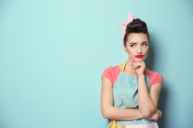 Photo of Portrait of funny young housewife on color background