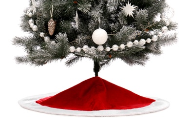 Photo of Decorated Christmas tree with red skirt on white background