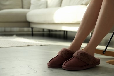 Photo of Woman in soft slippers at home, closeup. Space for text