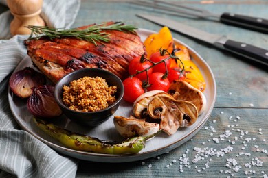 Photo of Delicious grilled meat and vegetables served on wooden table, closeup