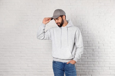 Photo of Portrait of young man in sweater at brick wall. Mock up for design
