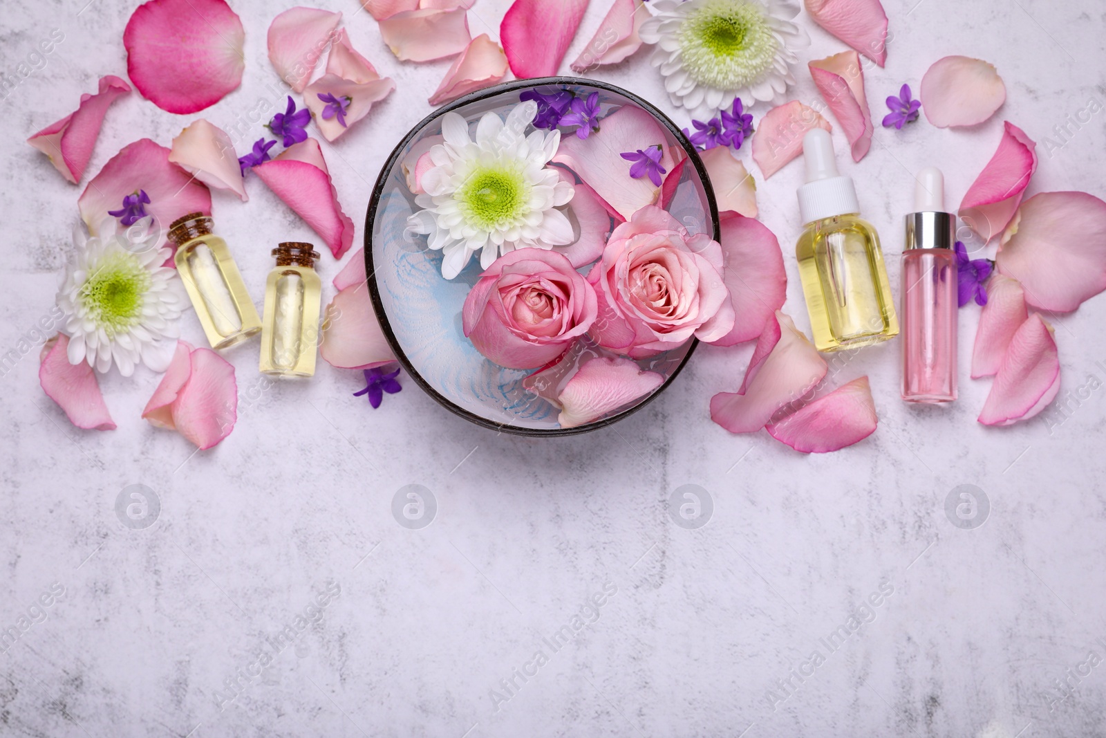 Flat lay composition with bowl of water and beautiful flowers on light table, space for text. Spa treatment Photo of Flat lay composition with bowl of water and beautiful flowers on light table, space for text. Spa treatment