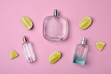 Photo of Flat lay composition with bottles of perfume and lime on color background
