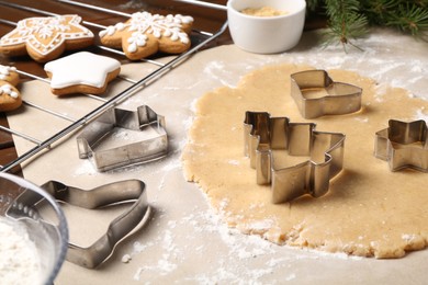Photo of Making Christmas cookies. Raw dough and different metal cutters on table
