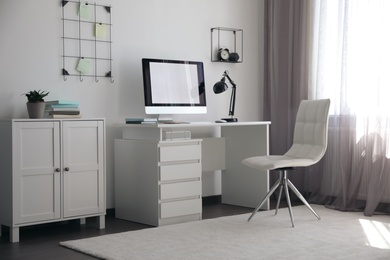 Photo of Comfortable white chair near desk in stylish office interior