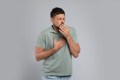 Photo of Man suffering from pain during breathing on grey background