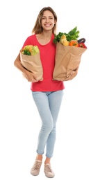 Photo of Young woman with bags of fresh vegetables isolated on white