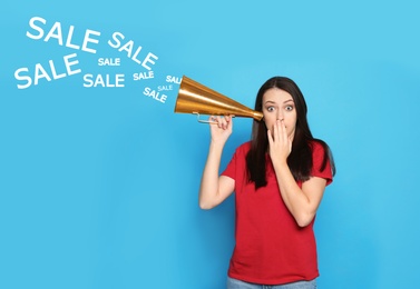 Photo of Emotional young woman with megaphone and words SALE on color background
