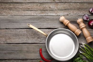 Photo of Flat lay composition with frying pan and fresh products on wooden table, space for text