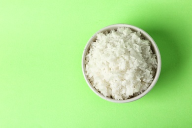 Photo of Bowl of boiled rice on color background, top view with space for text