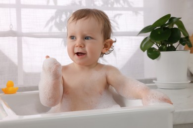 Photo of Cute little baby bathing in sink at home