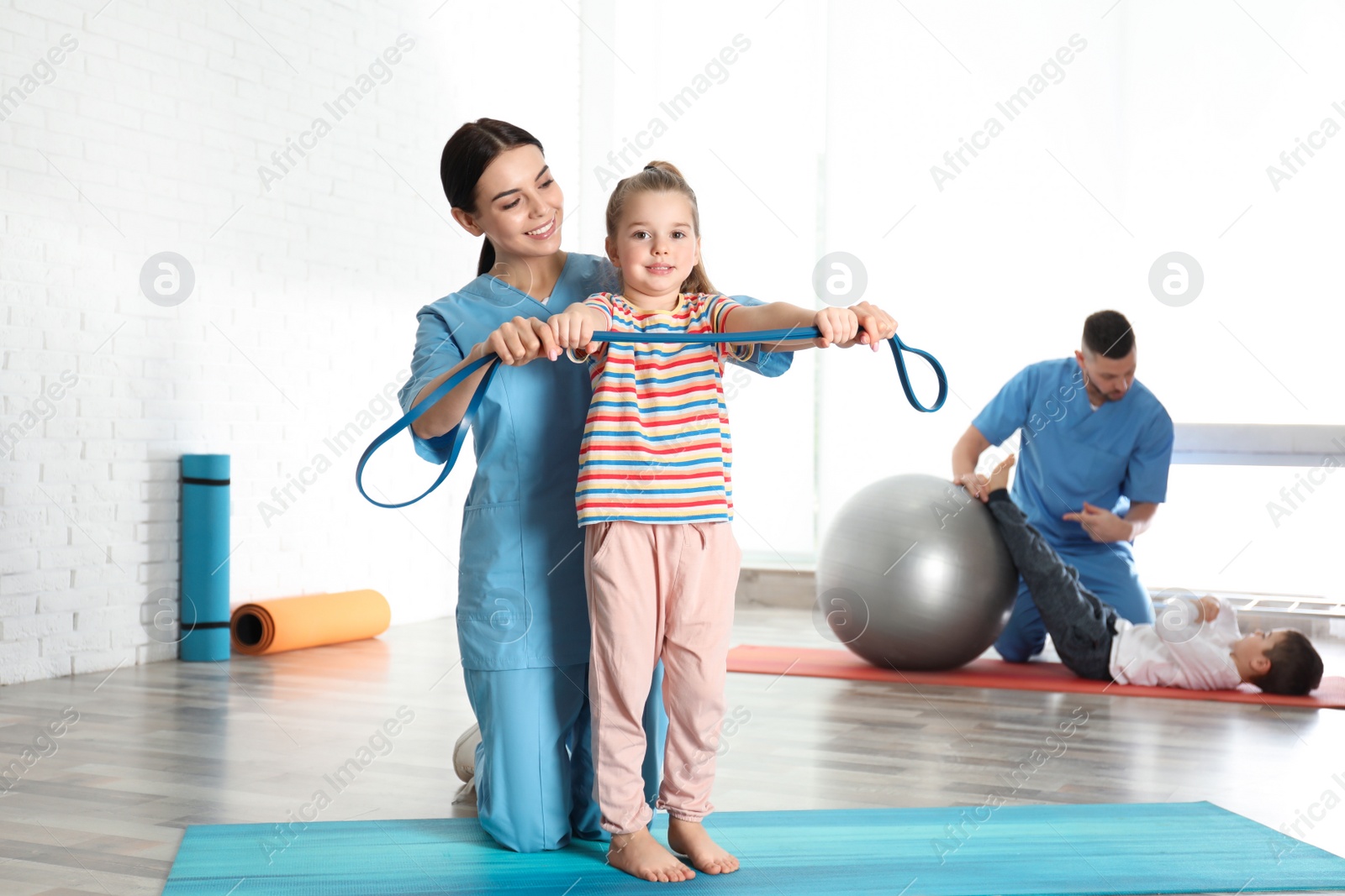 Photo of Orthopedists working with little children in hospital gym