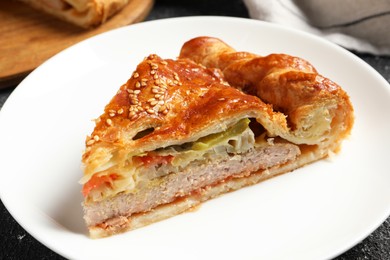 Photo of Piece of tasty homemade pie with filling on black table