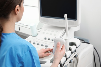 Sonographer operating modern ultrasound machine in clinic
