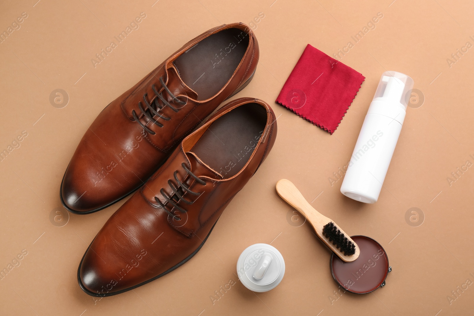 Photo of Flat lay composition with shoe care accessories and footwear on brown background