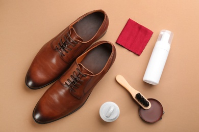 Photo of Flat lay composition with shoe care accessories and footwear on brown background