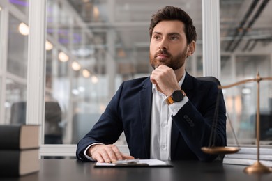 Photo of Portrait of confident lawyer at table in office