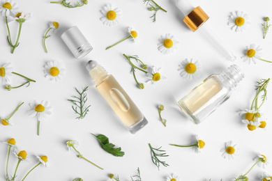 Flat lay composition with chamomile essential oil on white background