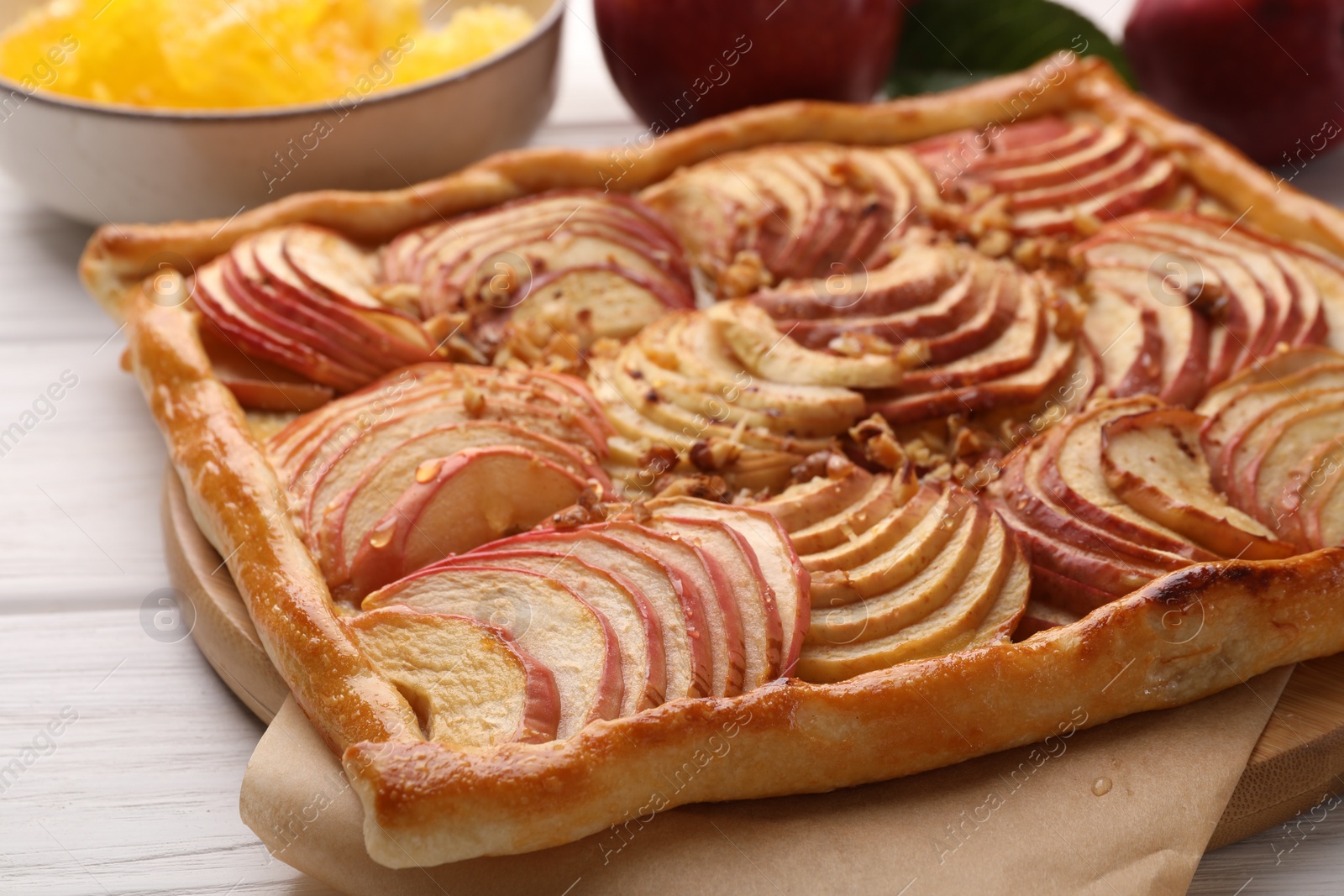 Photo of Tasty fresh apple galette and ingredients on white wooden table, closeup