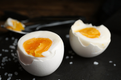 Photo of Tasty boiled chicken eggs on black slate plate, closeup