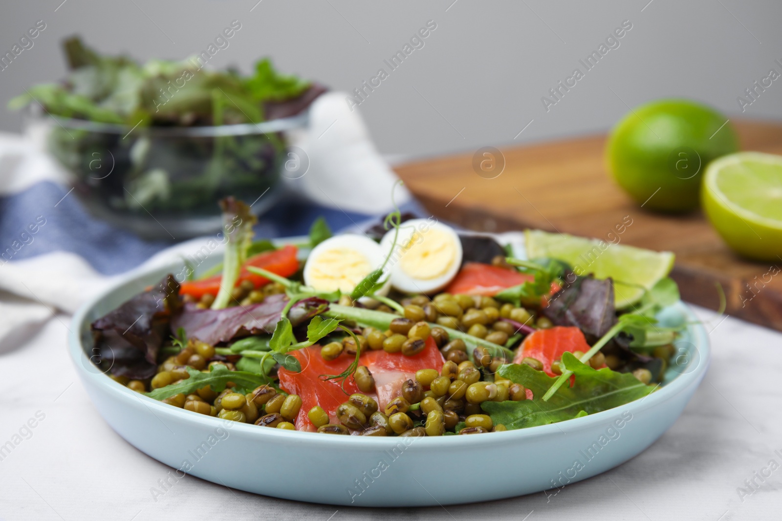 Photo of Plate of salad with mung beans on white marble table